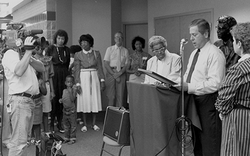 black and white photo of gathering with podium