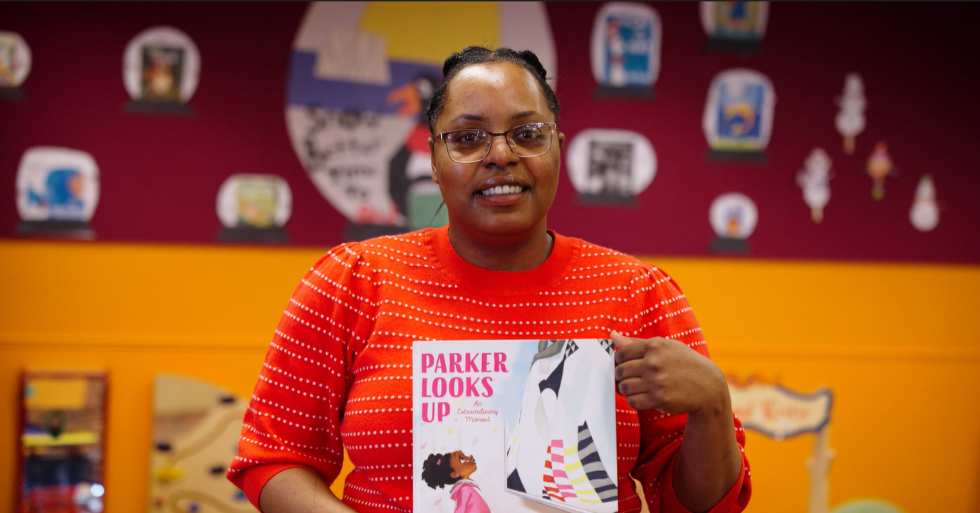woman smiling while holding picture book