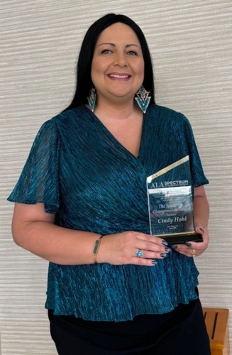 Woman stands with trophy