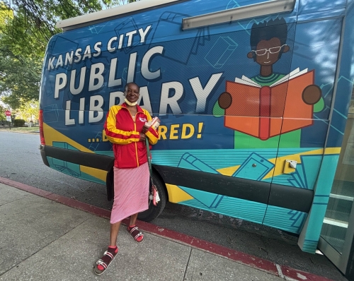 A Library patron stands in front of the Bookmobile at Nowlin Apartments.