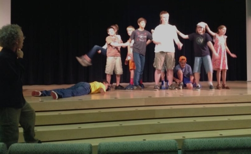 Students on stage, as instructor John Mulvey looks on, during the Young Actors Workshop at the Plaza Branch.