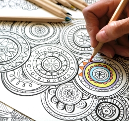 person using colored pencil on page