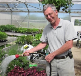Ben Sharda waters plants in the Kansas City Community Gardens greenhouse.