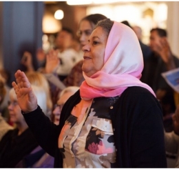 A woman raised her hand during a naturalization ceremony at the Library.