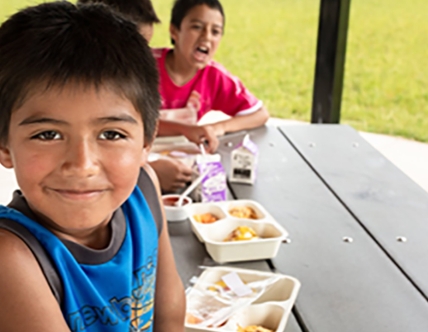 kid smiling at picnic table
