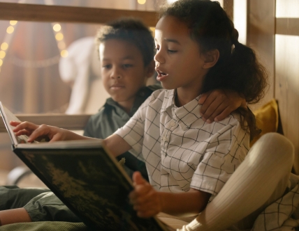 two kids reading book together