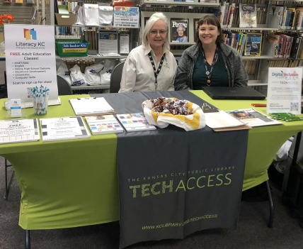 two women behind table smiling