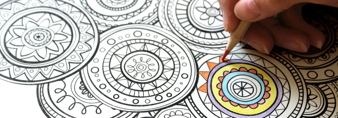 person using colored pencil on page