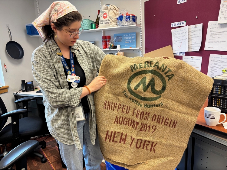 Senior Library Assistant Clyde Miedema holds up a coffee bag used in a crafting session at the Library.