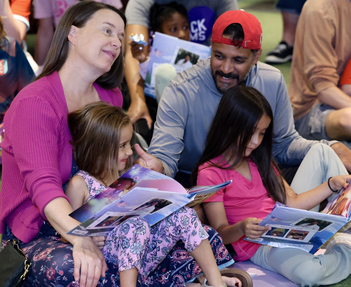 family sits and reads picture book